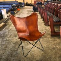 BUTTERFLY CARAMEL DÉMONTABLE Chaise avec structure en tubes d'acier, finition noir, assise en forme de papillon en cuir. Réplique de la chaise BKF créée par Bonet, Kurchan et Ferrari Hardoy en 1938.