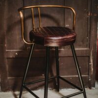 THABO Tabouret haut de style Mid Century avec structure en tubes d'acier, finition peinture powder coated, assise en cuir. Dossier avec finition en laiton. | Trouvez-le chez Mister Wils. Plus de 4000m² d'exposition. Buffets, étagères, luminaires, tables, chaises, canapés et banquettes, tabourets, ventilateurs, plantes artificielles...